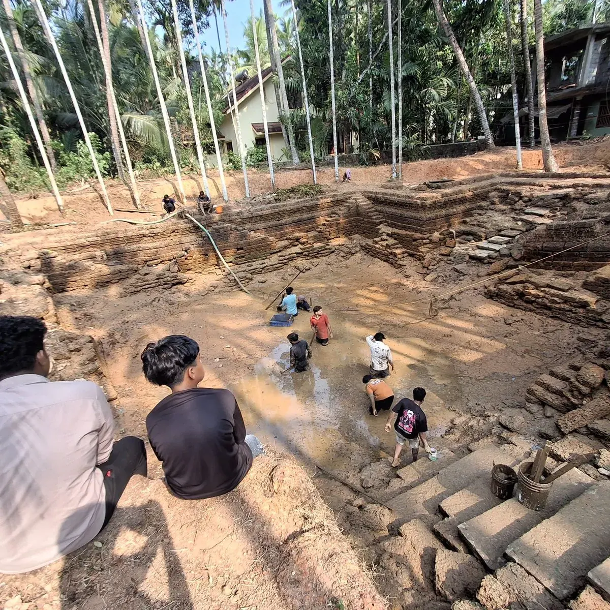 Community volunteers working in the temple pond during renovation