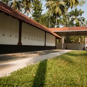 Temple grounds and side view with green lawn and coconut palm trees